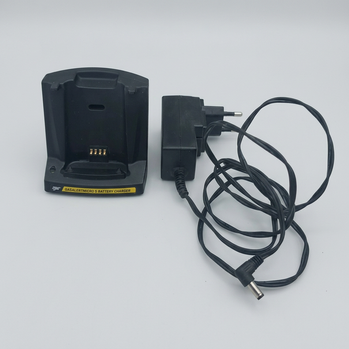 BW GasAlert Micro 5 battery charging cradle with black power adapter and cable on a light background.